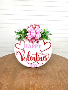 a sign that says happy valentine's day sitting on top of a wooden table