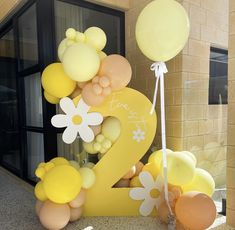 the number two is decorated with balloons and flowers