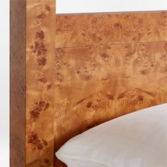 a bed with a wooden headboard and white pillows on it's sides,