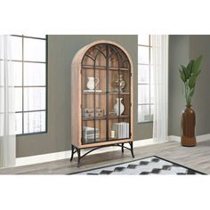 a wooden display case with glass doors and shelves on the front, sitting in a living room