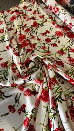 a red and white floral print fabric with green stems on the bottom half of it