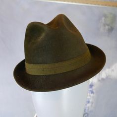 This classic 1960s German vintage olive brown smooth rabbit fur felt trilby hat has a 1.5-inch (3.81cm) brim and a 1-inch (2.54cm) band. The water-repellent fedora is lined in an black satin viscose fabric. Note that all hats I sell have been professionally cleaned and sanitized. Brand label: Ottmar Reich (Germany) Size: Small US = 6 7/8 UK = 6 3/4 EU = 55 Inches = 21 5/8 (54.93cm) Top front to inner brim = 3.5 inches (8.89cm) Condition: Excellent (clean, soft, and supple, with no stains, tears, Retro Fedora Hat For Formal Occasions, Vintage Brown Fedora For Formal Occasions, Retro Fitted Fedora With Curved Brim, Fitted Retro Fedora With Curved Brim, Retro Fedora With Curved Brim, Retro Fedora With Short Brim For Formal Events, Retro Fedora With Short Brim For Formal Occasions, Retro Short Brim Fedora For Formal Occasions, Retro Short Brim Fedora For Formal Events