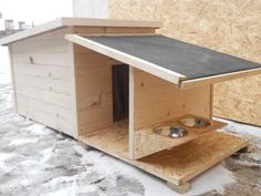 a dog house made out of plywood with two bowls on the outside and one in the inside