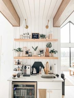 a kitchen with open shelving and white walls