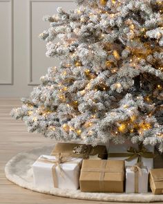 a white christmas tree with presents under it