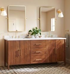 a bathroom with two sinks and mirrors on the wall next to a checkered rug