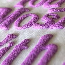 the words are made out of purple thread