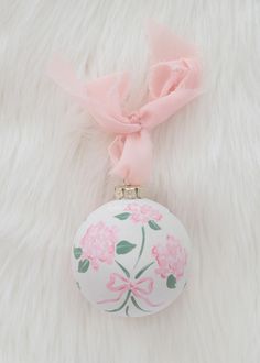 a white ornament with pink flowers on it