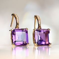 A stunning pair of 18k yellow gold earrings feature emerald-cut amethysts, which weigh approximately 8.18 carats in total. Single-cut diamonds, which are latch-backs, are set along the fronts of the closures. The diamonds weigh approx. 0.13 carat combined. The length of this earring is approximately 2.3cm.      ✦ GEMSTONE  SPECIFICATIONS:   Amethyst Weight: Approx 8.18 Carats   Amethyst Cut: Emerald Cut   Diamond Weight: Approx 0.13 Carats    ✦ EARRING SPECIFICATIONS:    Material: 18k Yellow Gol Amethyst And Diamond Earrings, Vintage Diamond Earrings, Dream Dark, Asscher Cut Ring, Fancy Diamond Ring, Estate Diamond Jewelry, Shiny Rings, Designer Diamond Jewellery, Colored Diamond Rings