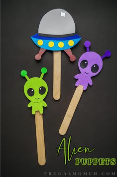 two alien popsicles are sitting next to each other on a black surface with the words alien popspies written below them