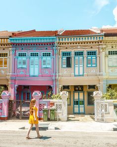 a woman walking down the street in front of colorful buildings