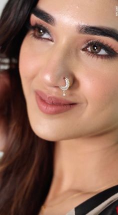 a close up of a person wearing a nose ring