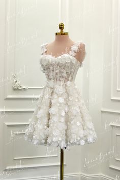 a white dress on a mannequin in front of a wall