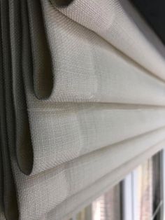 a close up view of some blinds in a window with the curtains pulled back and closed