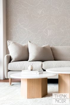 a white couch sitting next to a coffee table on top of a carpeted floor