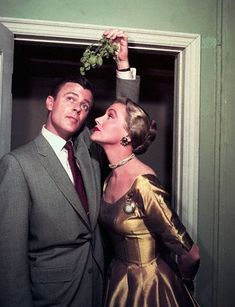 a man in a suit and tie standing next to a woman wearing a gold dress