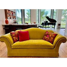 a living room filled with furniture and a grand piano in the back drop down window