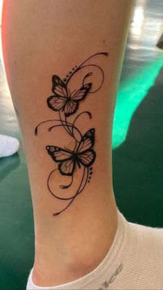 a woman's leg with a butterfly tattoo on the lower part of her leg