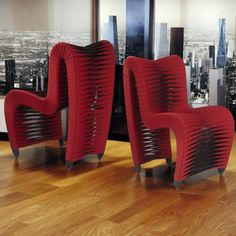 two red chairs sitting on top of a hard wood floor