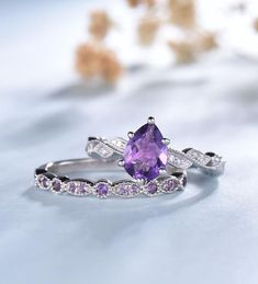 an image of two rings with purple stones on them