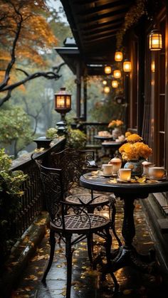 an outdoor patio with tables and chairs on it, lit by lanterns hanging from the ceiling