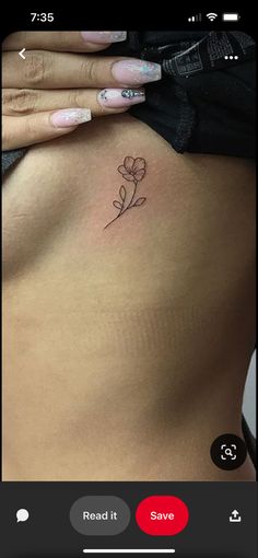 a woman's stomach with a small flower tattoo on her left side ribcage