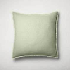 a light green pillow on a white wall