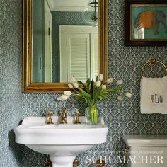 a white sink sitting under a bathroom mirror next to a wall mounted faucet