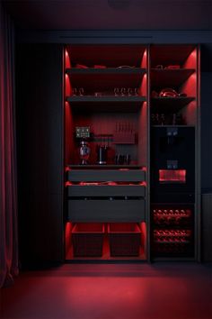 an open cabinet with red lighting in the dark