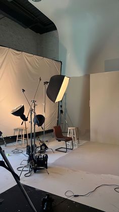 an empty photo studio with lighting equipment and lights on the floor in front of it