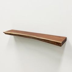 a wooden shelf mounted to the side of a wall