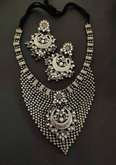 Add style and charisma to your beautiful personality with this exquisitely designed and handcrafted high quality silver look alike necklace set .Pair it up with any casual, semi formal or, formal attire and gather compliments for your unique and classy choice. Ideal wear for both casual and dressy occasions Necklace length 24 inches with an adjustable black dori at the back Weight 180 GM's Each earring weighs 20 GM's ( earrings are light weight and comfortable to wear) Length 3.5 inches Note: Al Bollywood Style Oxidized Metal Jewelry, Bollywood Style Silver Metal Chandbalis, Elegant Silver Jewelry With Mirror Work, Elegant Kundan Necklace With Oxidized Finish For Festivals, Bollywood Style Jewelry With Oxidized Finish For Party, Bohemian Silver Jewelry Sets With Stone Work, Silver Hand Set Chandbalis For Diwali, Hand Set Silver Chandbalis For Diwali, Heavy Silver Kundan Necklace For Festive Occasions