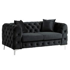 a black velvet couch with two pillows on it's back and one arm facing the camera