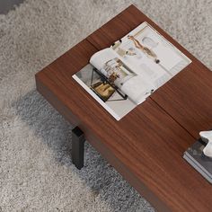 a coffee table with magazines on it in the middle of carpeted flooring area