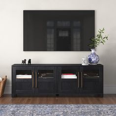 an entertainment center in the living room with a large television mounted on the wall above it