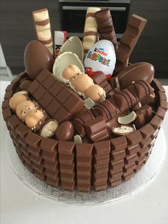 there is a cake that has chocolate decorations on the top and it's made to look like people in a basket