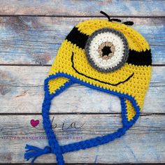 a crocheted yellow and blue hat with a small eyeball on the front