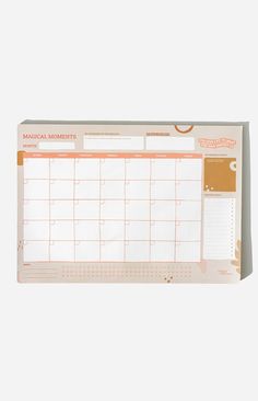 an orange and white desk calendar with the month on it's front page, sitting on top of a table