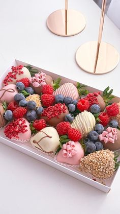 a box filled with lots of different types of chocolate covered strawberries and raspberries