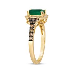 a gold ring with an emerald and brown diamonds on the side, set in 18k yellow gold