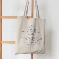 a tote bag hanging on a wooden chair with the words apris sucub