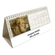 a desk calendar with a photo of a lion on the front and side of it