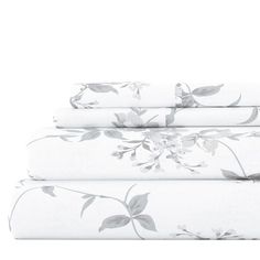 three sheets with white flowers on them and one is folded in front of the other