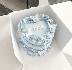 a heart shaped cake in a white box with butterflies on the top and number 891