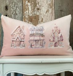 a pink pillow sitting on top of a white chair