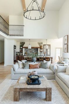 a living room filled with furniture and a large chandelier above the couches