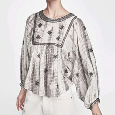 From Zara Comes This Embroidered And Embellished Boho Style Gray And White Tie Dye Blouse In Sz Small. In A Peasant Style Silhouette With 3/4 Balloon Sleeves, Dolman Style, Slightly Cropped Detail, Black Beading And Embroidered Detail Along Neckline And Yoke As Well As Sleeve Hems, Geometric Stitched Embroidery Throughout, Back Button Closure. Crew Neck. Measurements Bust Flat Approximately 23” Length 22”. Chic Cotton Blouse With Embroidered Sleeves, Chic Summer Blouse With Embroidered Sleeves, White Puff Sleeve Top With Floral Embroidery, White Puff Sleeve Tops With Embroidered Sleeves, Chic Summer Tops With Embroidered Sleeves, Chic Summer Top With Embroidered Sleeves, White Embroidered Lantern Sleeve Blouse, Chic White Tops With Embroidered Sleeves, Long Sleeve Blouse With Pearl Embroidery