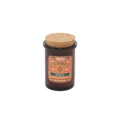 an orange jar with a cork lid and label on it, sitting on a white surface