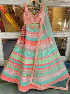 This multicolored banarsi, chanderi silk mixed panelled lehenga is paired with a rainbow mirror work choli.  The outfit is completed with a mint net mukaish dupatta.
NOTE: Ready-to-Ship in a size Medium. Ships in 3 days. Designer Multicolor Lehenga With Zari Work, Designer Multicolor Lehenga With Mirror Work, Designer Multicolor Lehenga With Resham Embroidery, Multicolor Chanderi Bollywood Sets, Anarkali Lehenga With Multicolor Mirror Work, Anarkali Style Multicolor Lehenga With Mirror Work, Multicolor Choli With Resham Embroidery For Reception, Multicolor Bollywood Chanderi Sets, Bollywood Multicolor Chanderi Sets