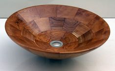 a wooden bowl that is sitting on a table with a white surface in front of it